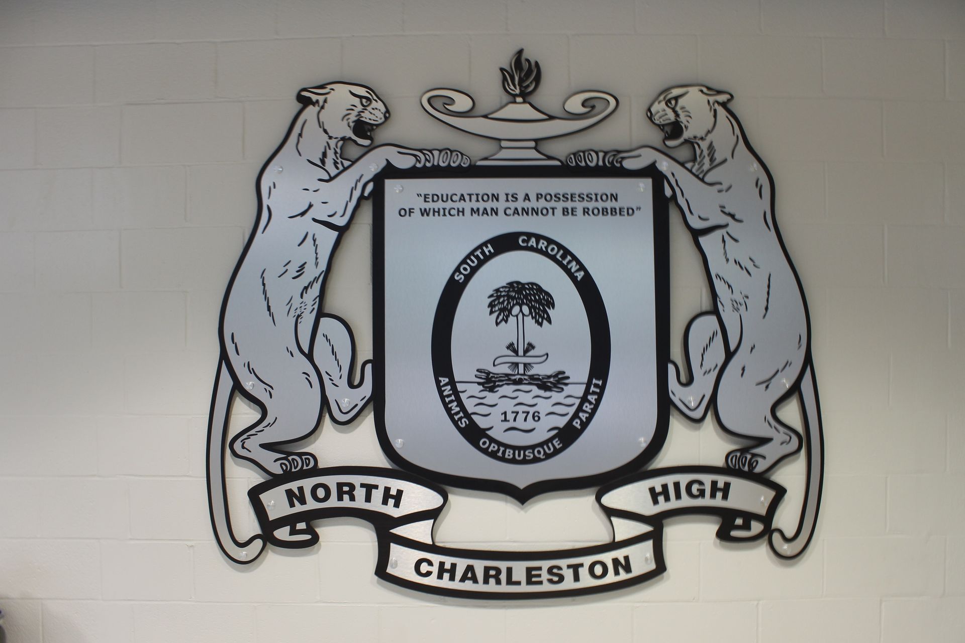 North Charleston High School emblem with two panthers flanking a shield, a Palmetto tree, and text.