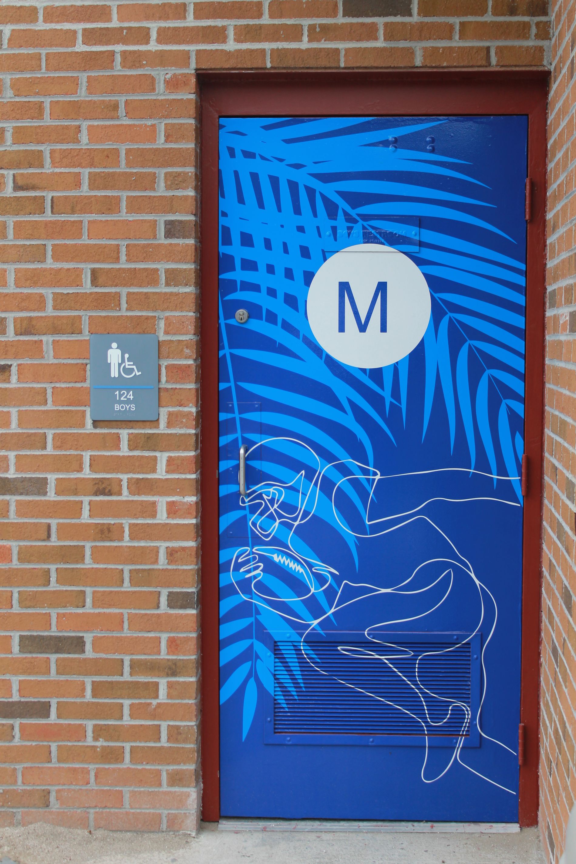 Men's restroom door with blue palm leaves design and the letter 