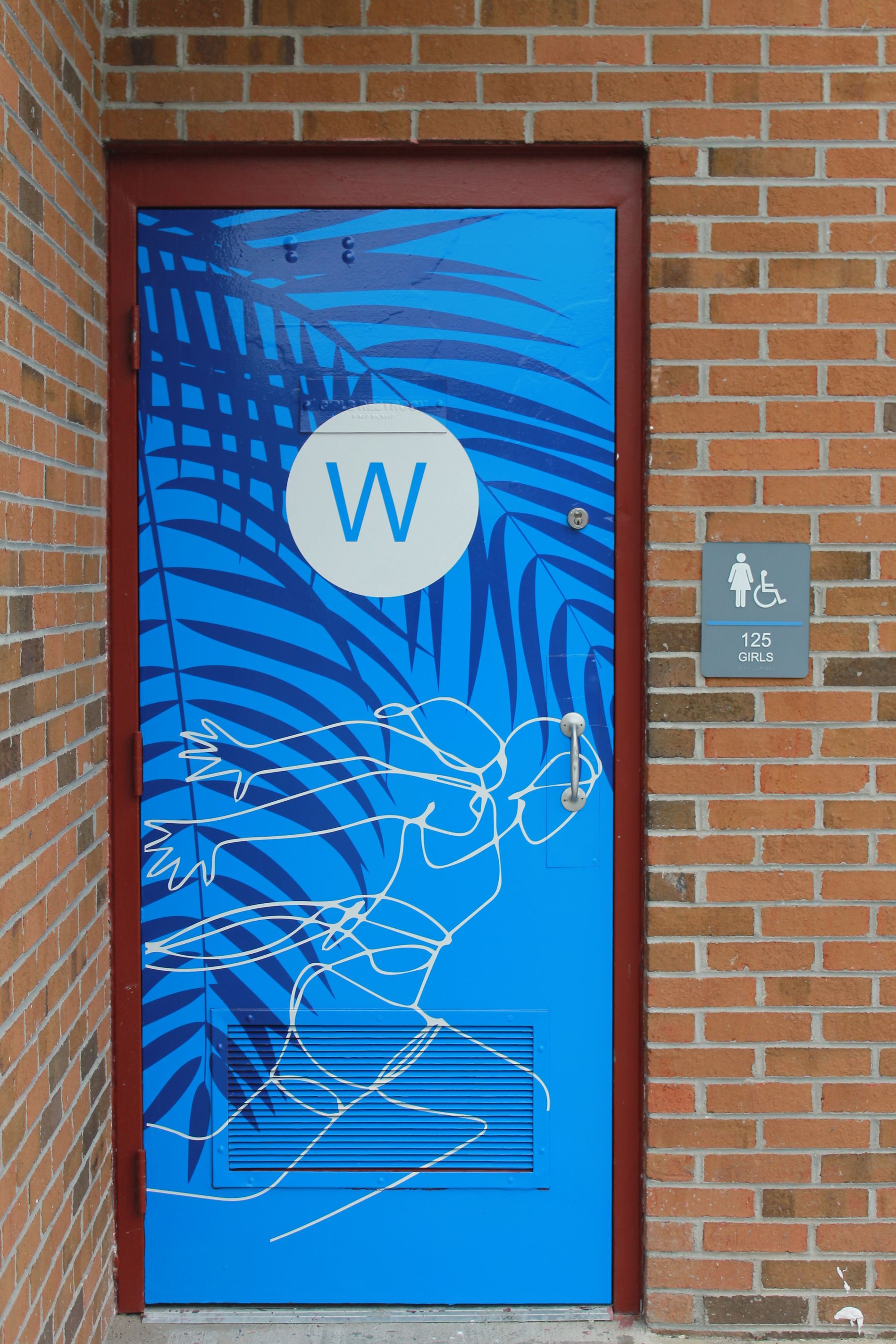 Blue restroom door with palm leaf design and 