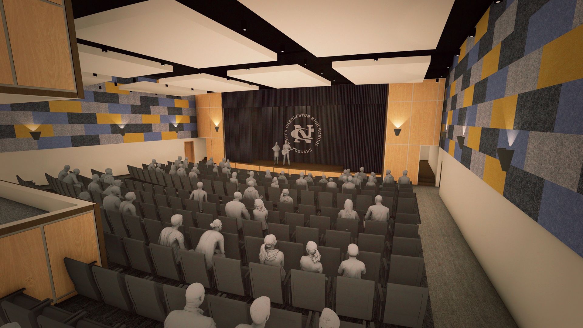 Auditorium interior with rows of seats facing a stage. Two figures on stage under a logo. Walls have acoustic panels.