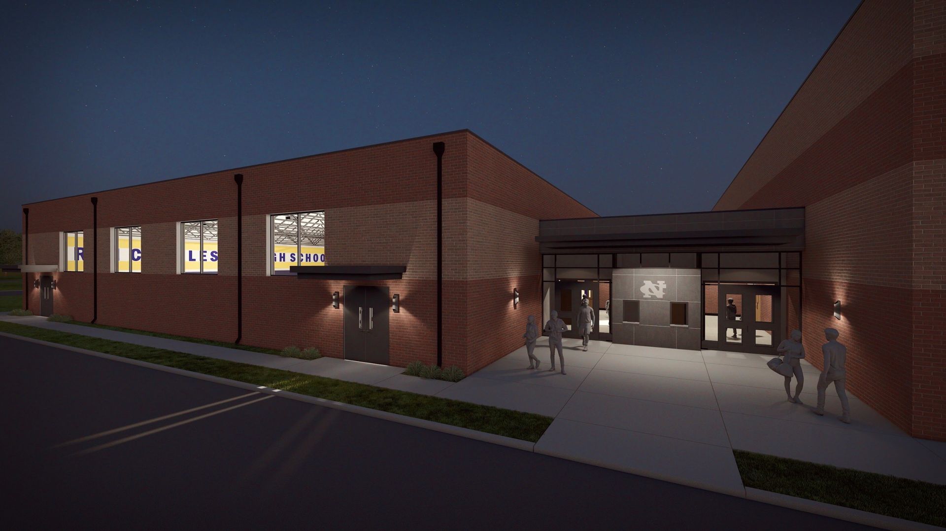 Brick building exterior at night; illuminated entrance with people entering.