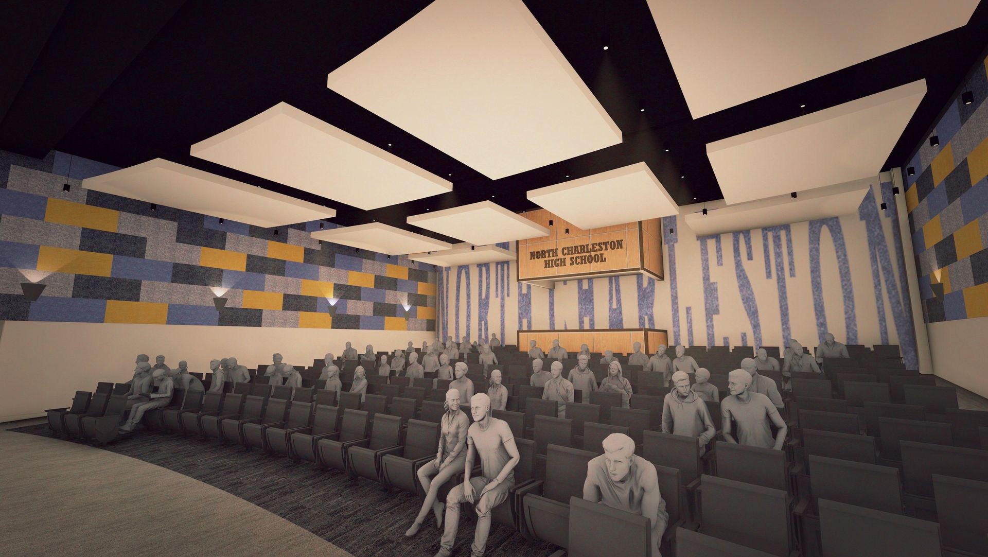 Auditorium with tiered seating, featuring a stage with banner, and acoustic panels on the ceiling.