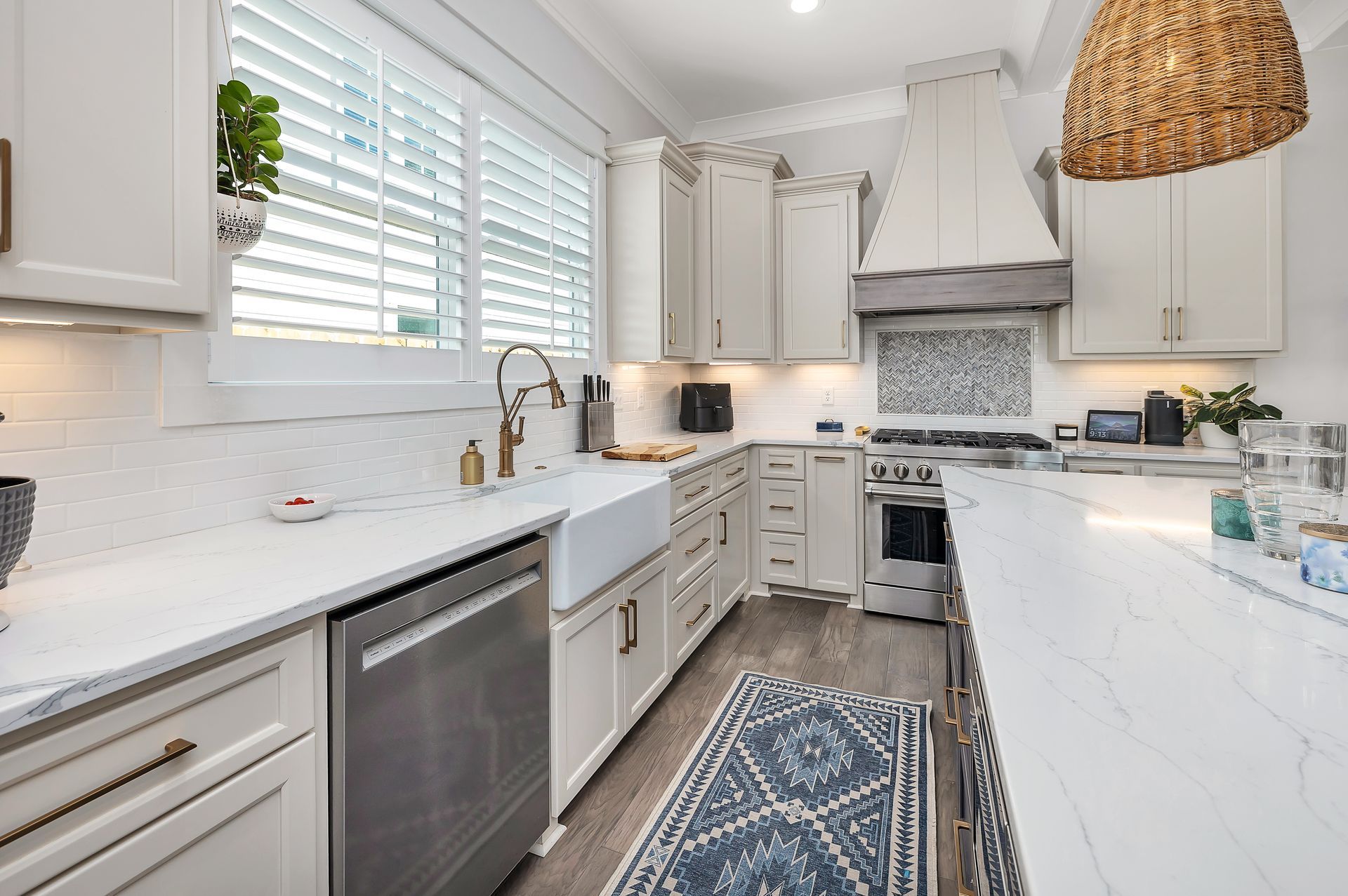 Bright, modern kitchen with white cabinets, stainless steel appliances, and a woven light fixture.