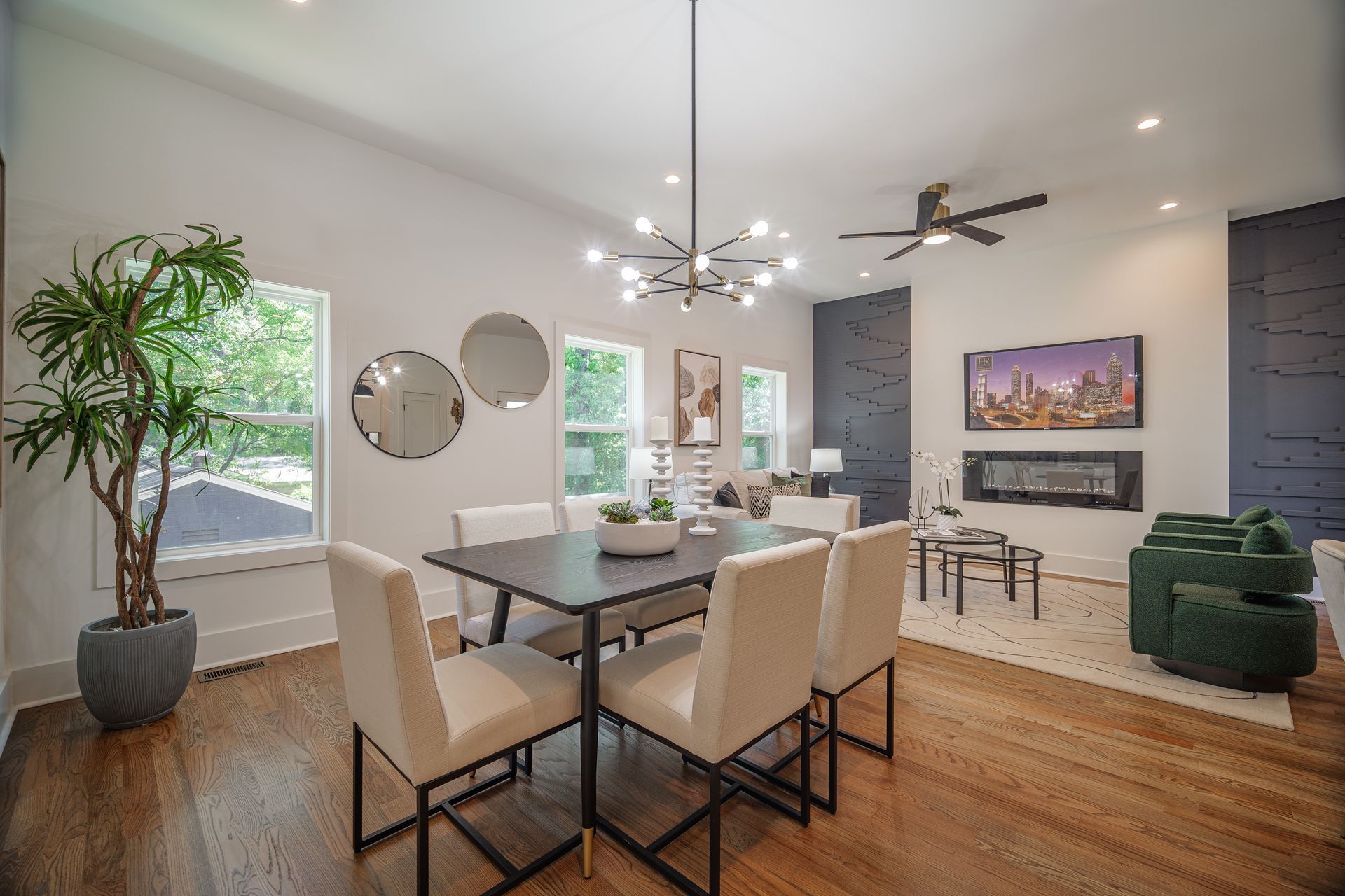 Modern dining room with a table, chairs, art, fireplace, and large windows.