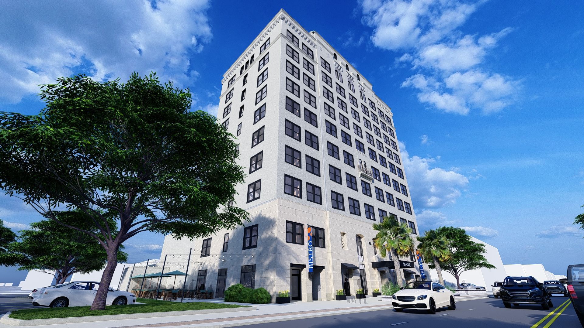 High-rise building with many windows, set on a city street with cars, trees, and blue sky.
