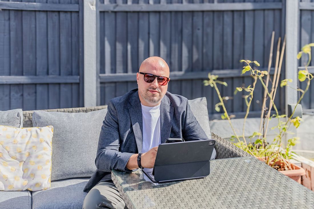 Daniel Ansell working outdoors on a laptop