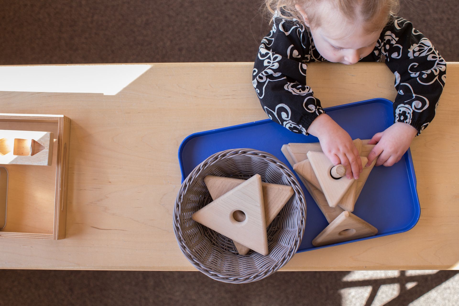 Montessori toddler working with a wood puzzle