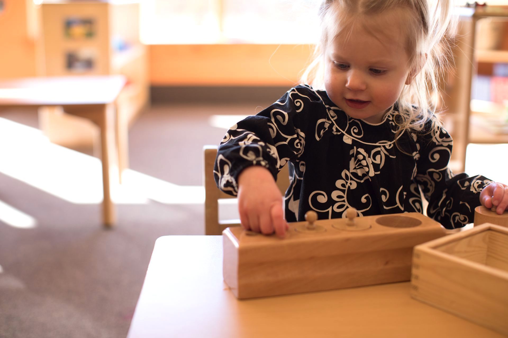 Montessori toddler working in knobbed cylinders