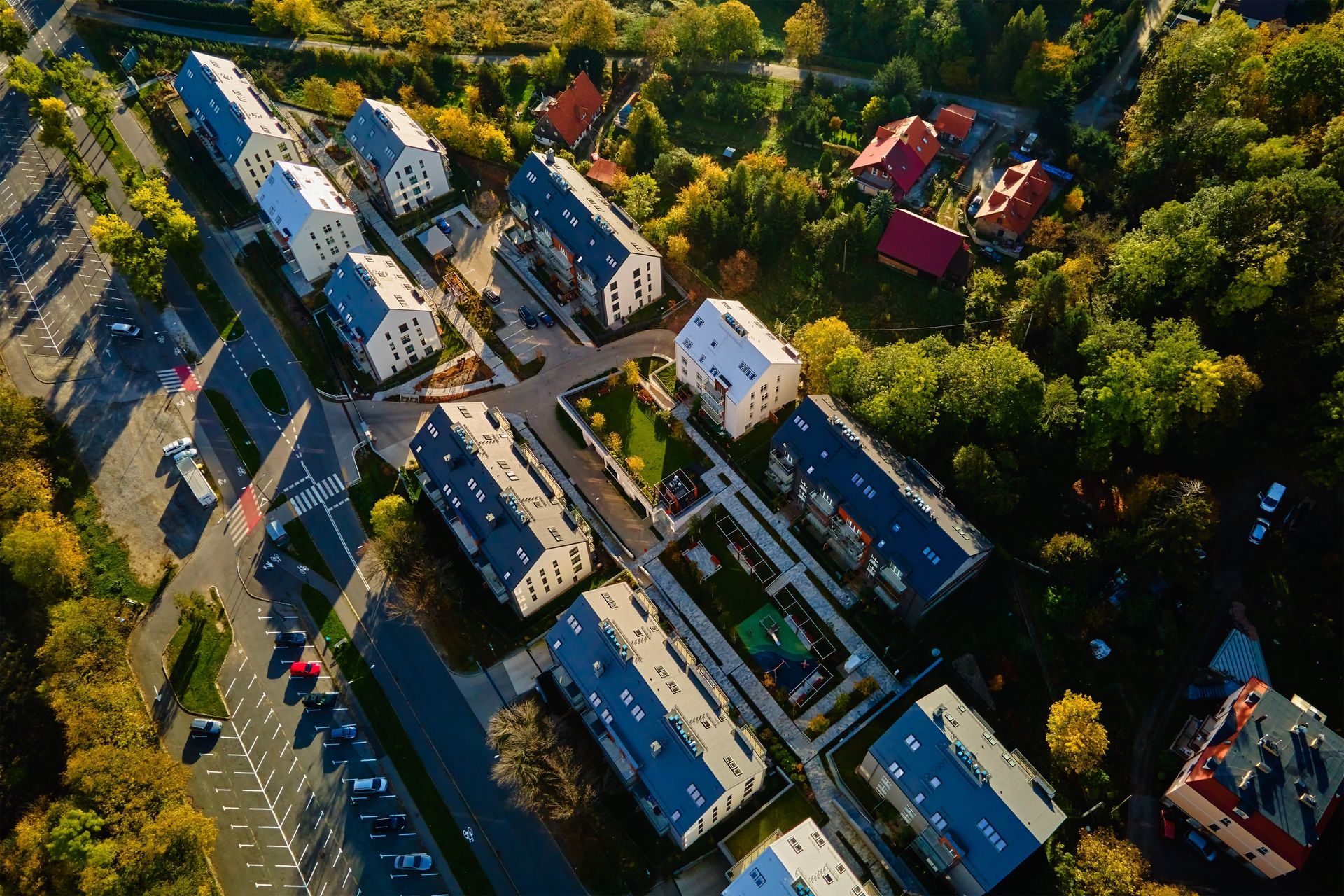 Aerial view of white houses and streets in a leafy residential neighborhood at sunset