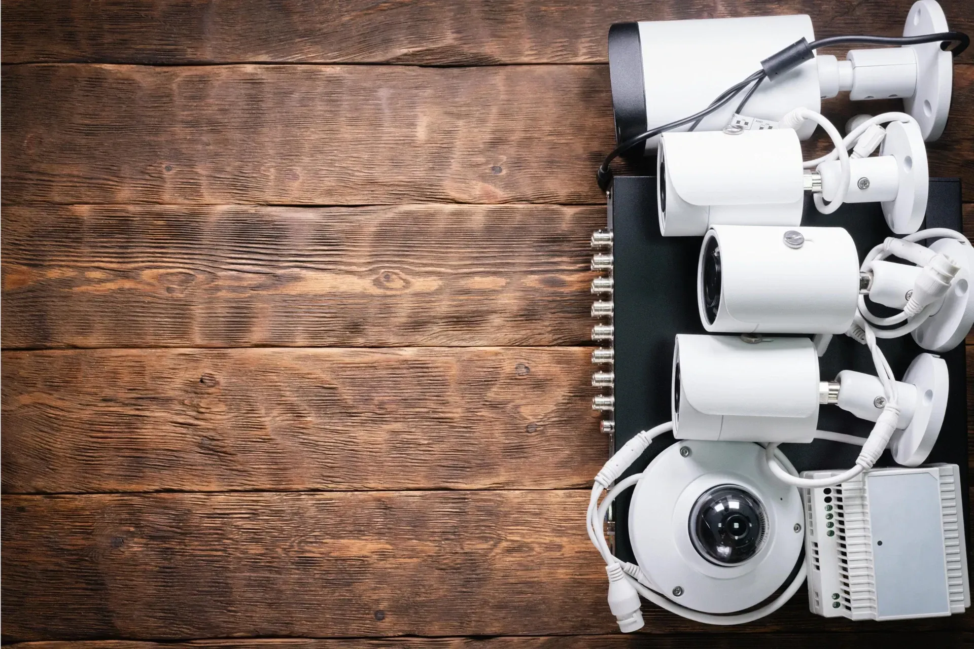 Different types of security cameras on a wooden background