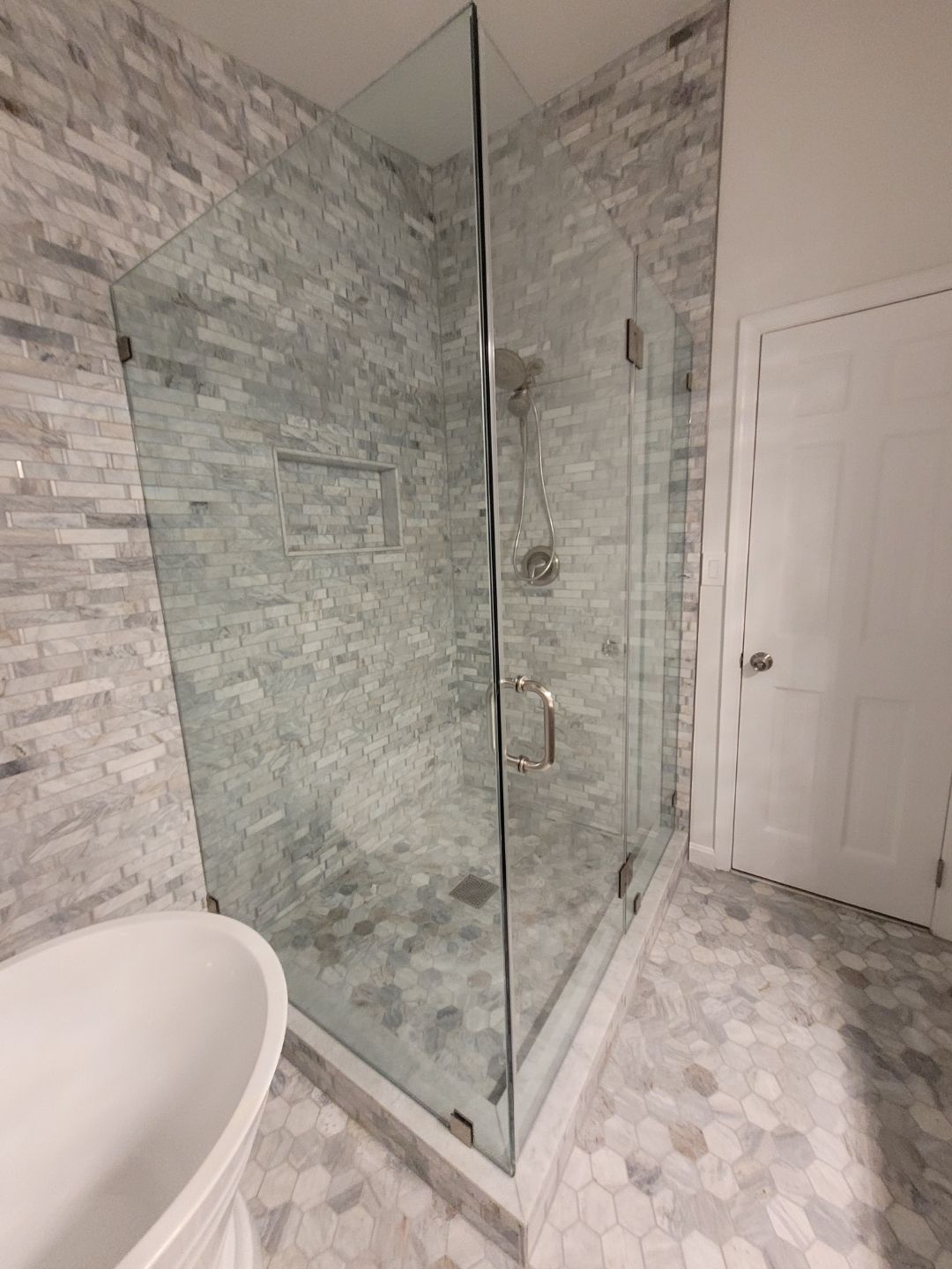 A bathroom with a tub , shower and window.