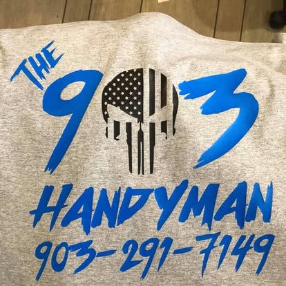 A light gray t-shirt with blue text and a black-and-white Punisher-style logo reading 
