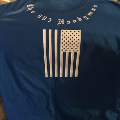 A blue t-shirt featuring a vertical white American flag graphic with the text 