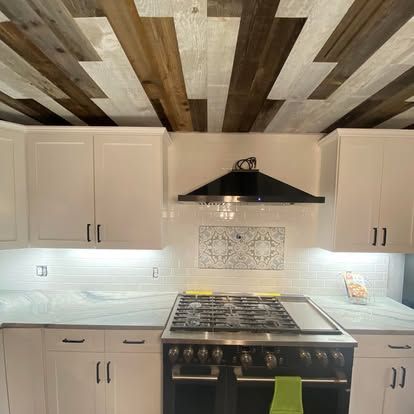 Kitchen with white cabinets, white subway tile backsplash, a black gas range, and a wood-planked ceiling.