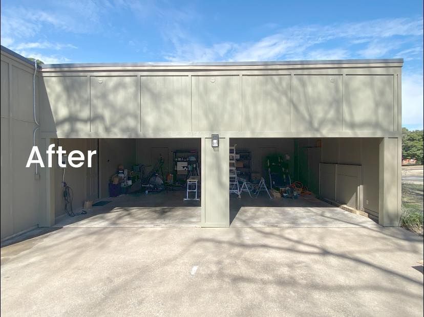 A two-car garage structure with smooth tan walls and open, empty bays under a blue sky.