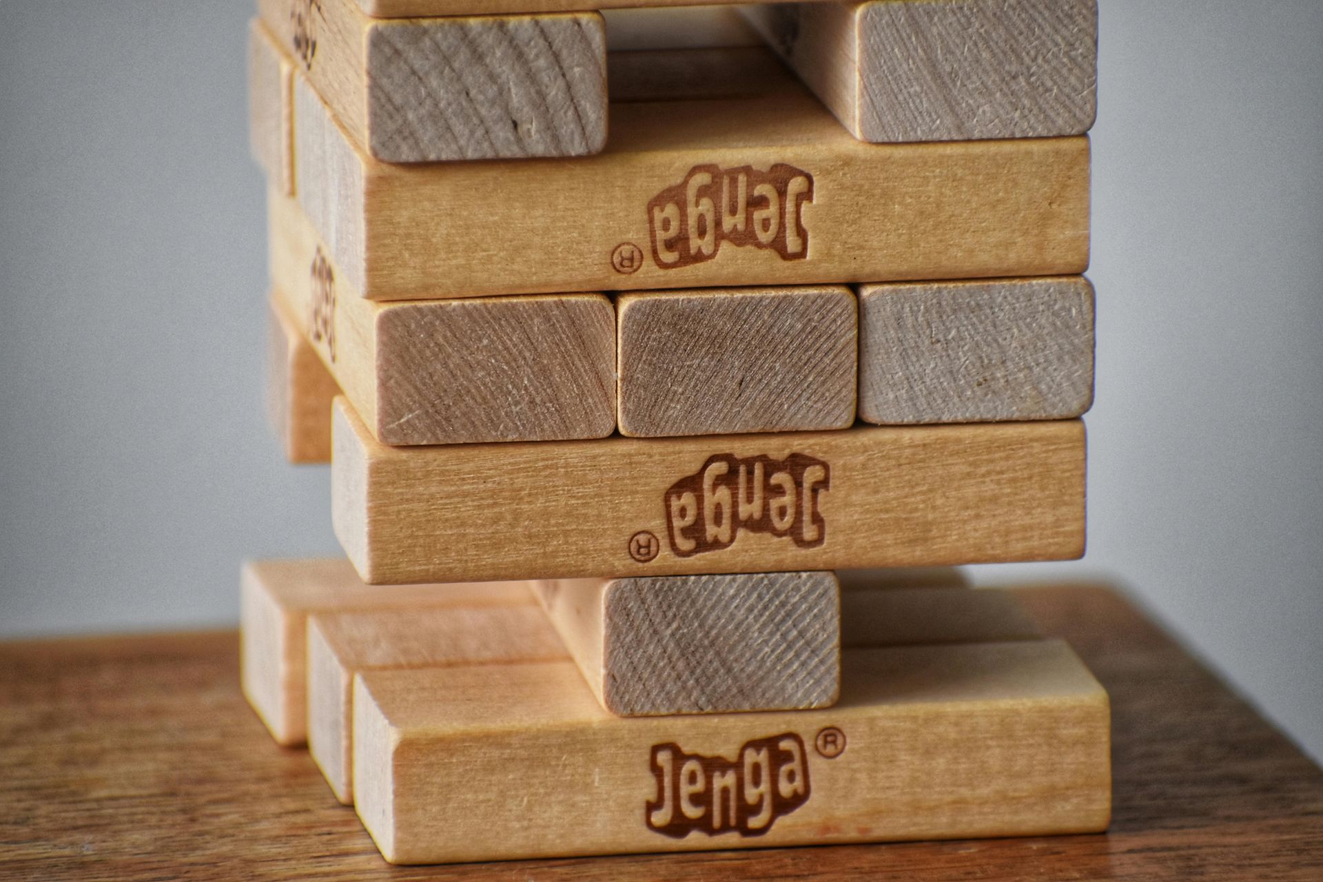 A partially constructed Jenga tower with the game's name imprinted on some blocks.