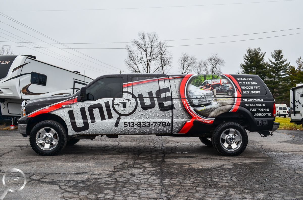 Branded red, black, and white SUV with “unbound” lettering parked on a wet lot