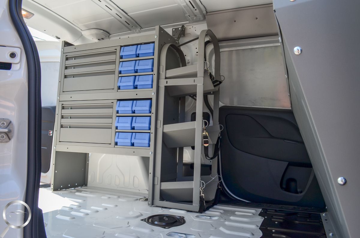 Interior of a cargo van with wall-mounted blue storage bins and shelves on the left side