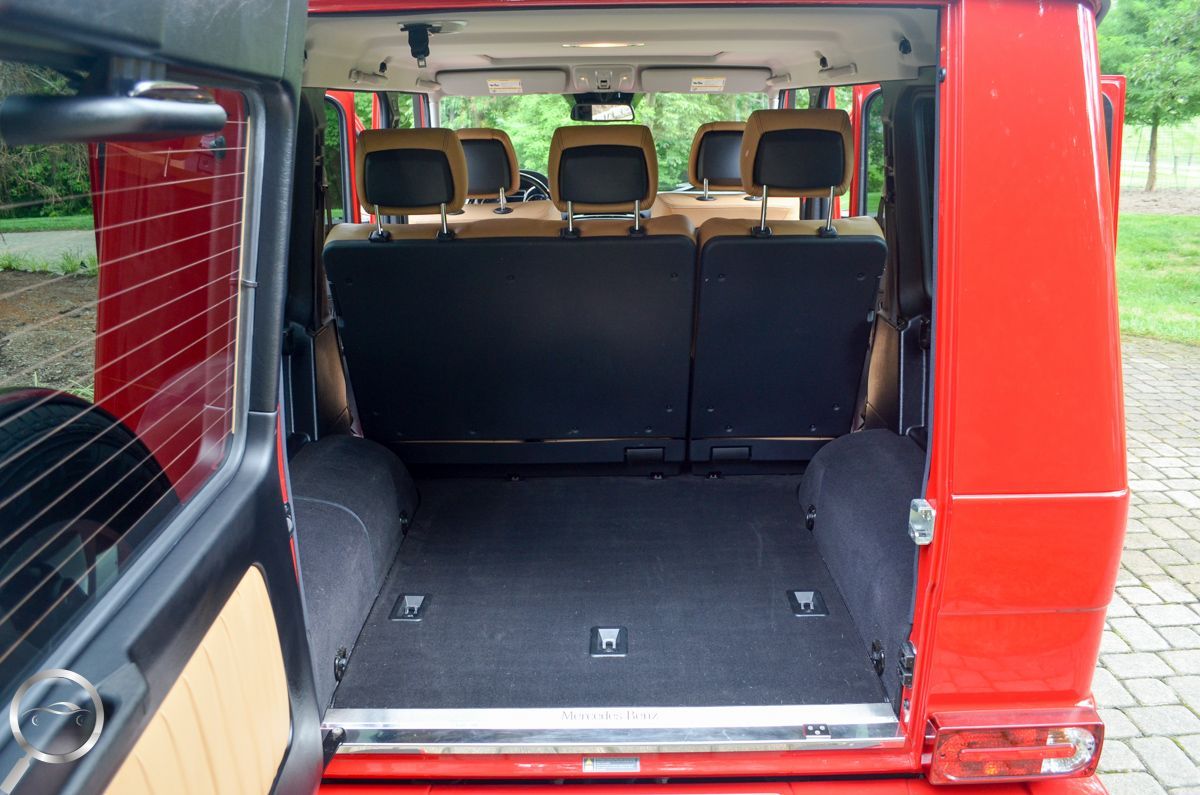 Open red van interior with rear seats folded down, showing a flat cargo area and window blinds.