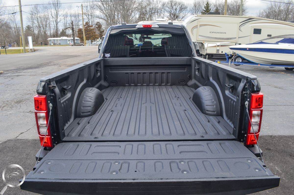 Open pickup truck bed with black liner and tailgate down, viewed from the rear
