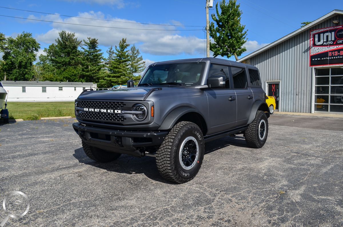 Matte black off-road SUV parked outside a garage on a sunny day
