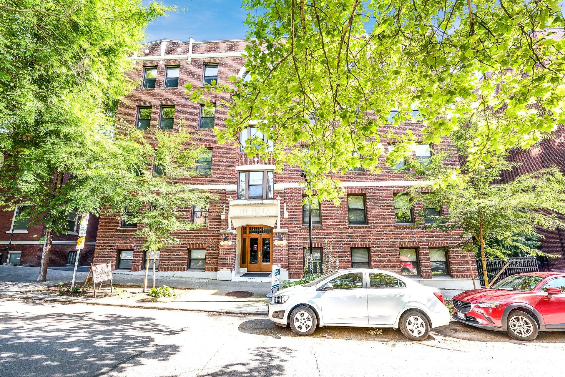 Photo of the the building, seen from the street, with a few parking spots out front