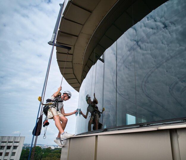 a mountaineering worker cleaning outside window building
