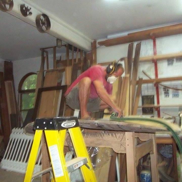 john hassay is kneeling on top of a piece of wood while sanding it