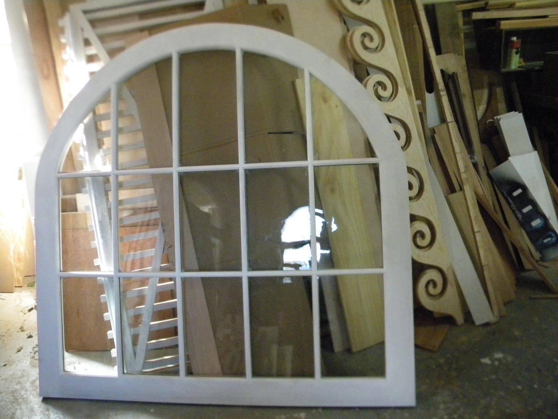a custom built white window frame with a reflection of a staircase in it