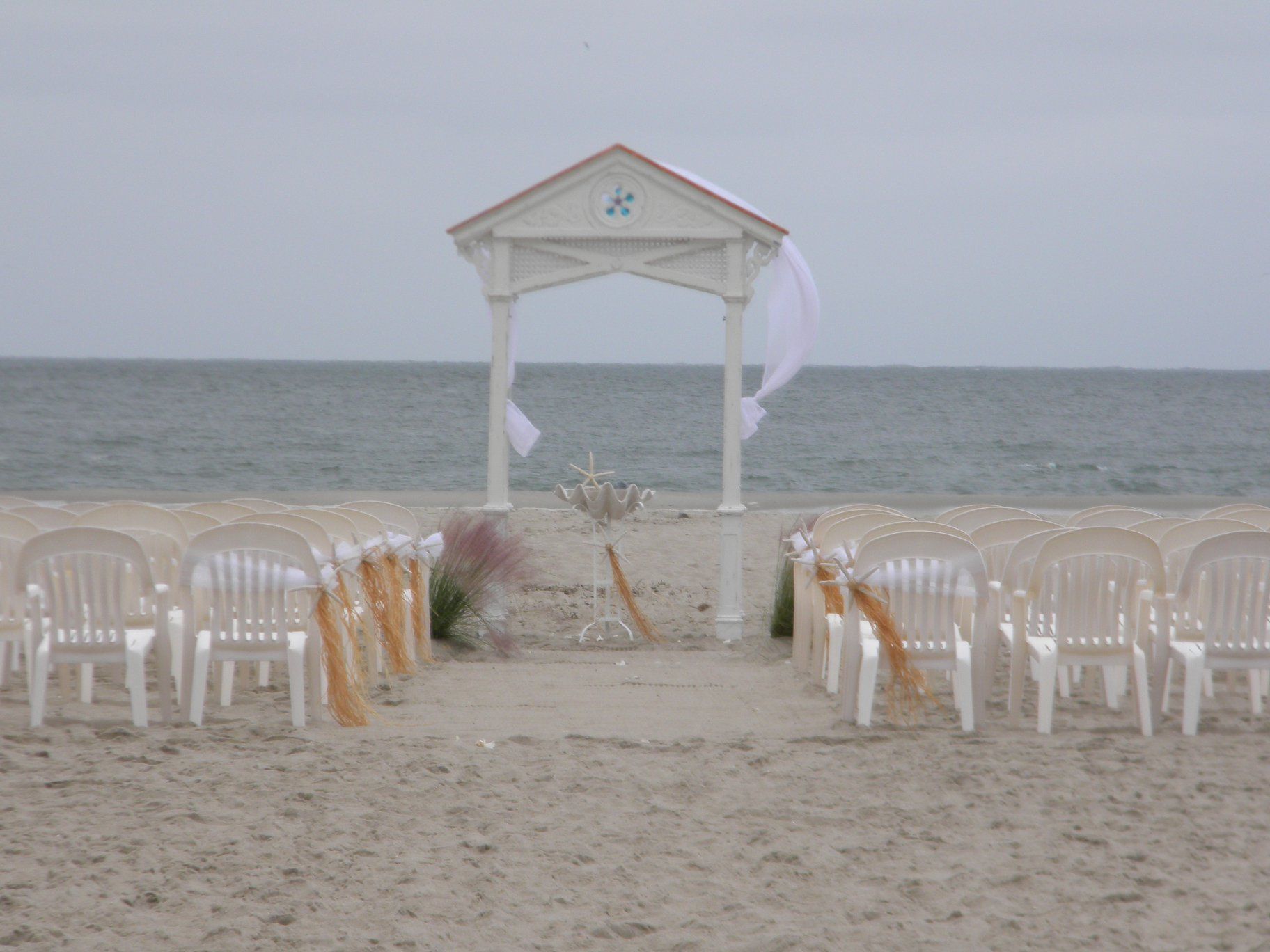a custom built white gazebo on the beach with a cross on it
