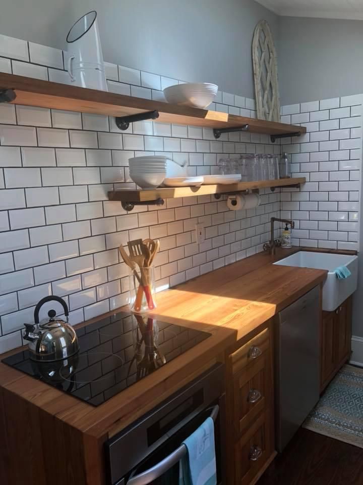 a kitchen with a custom wood counter top with stove top oven and a sink