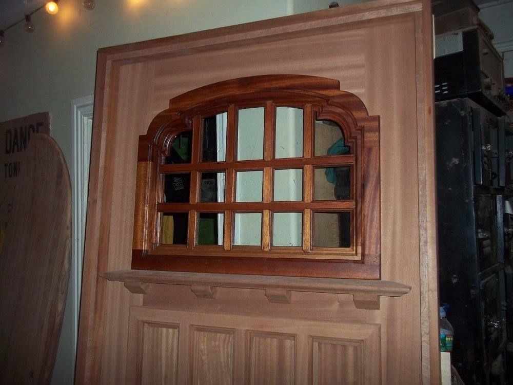 a wooden reproduction door with a window and a sign that says bang on it
