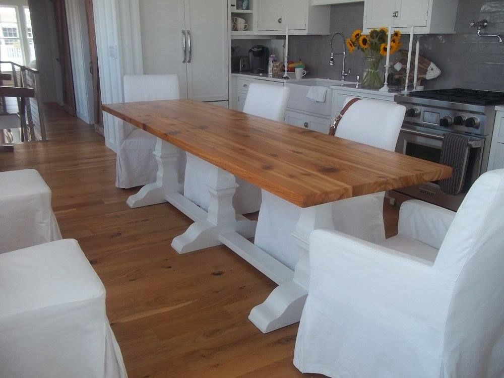 a kitchen with a wooden table and white chairs