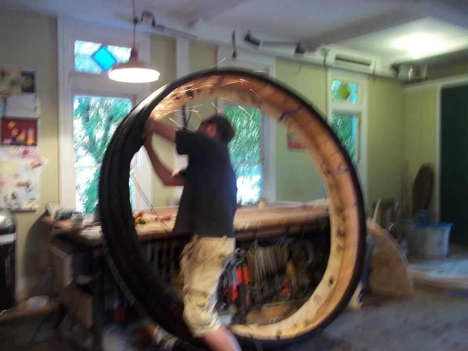 john hassay is working on a large circular wooden object inside the cape island woodworks workshop