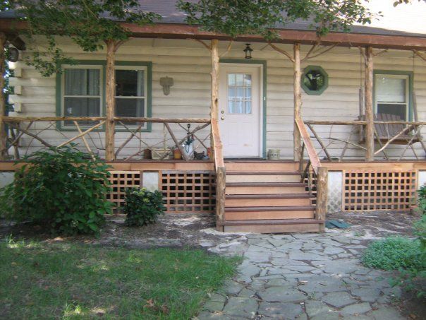 a white house with a rustic looking wood railings and steps