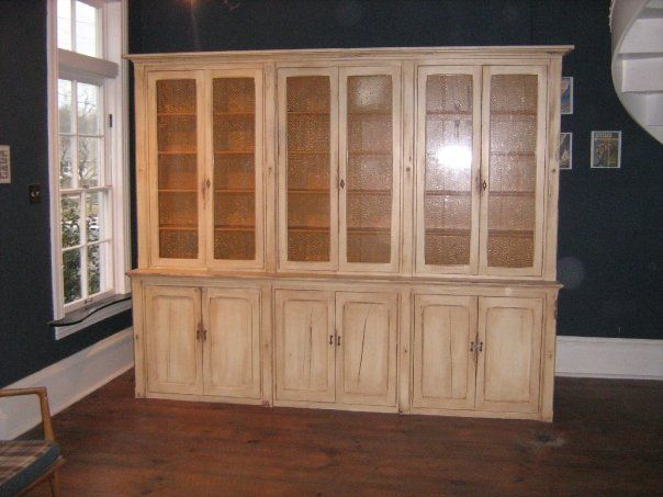 a large custom built wooden cabinet with glass doors in a room