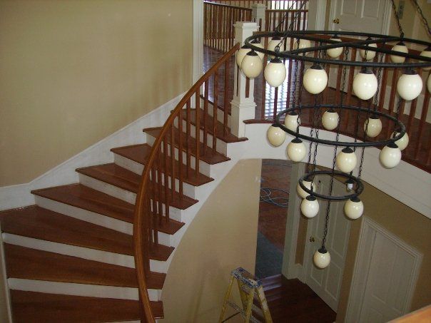 a custom built wooden spiral staircase with a chandelier hanging from the ceiling
