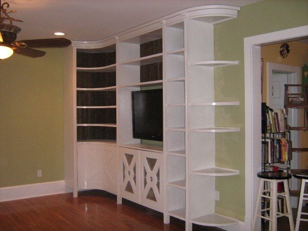 a living room with white built-in shelves and a flat screen tv