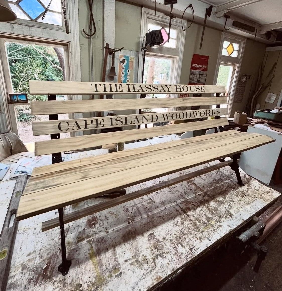 A wooden bench that says the hassay house on it