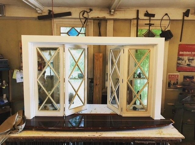 a white wood reproduction window is sitting on top of a wooden table in a room