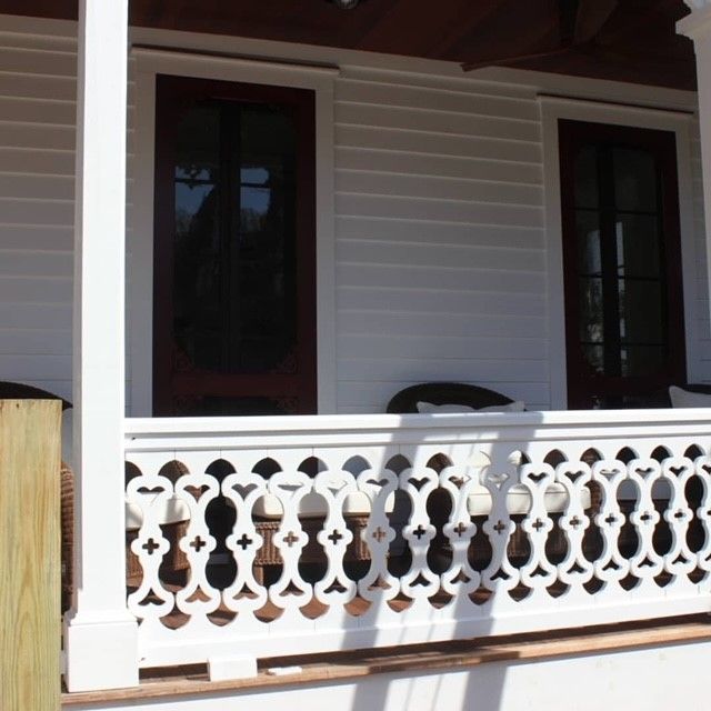 a porch with custom white wood railing and two windows