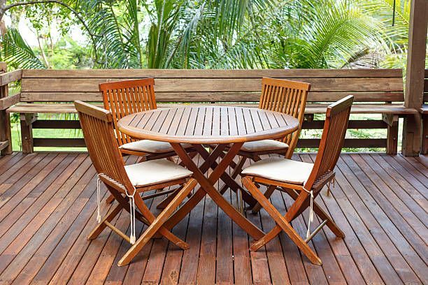 a wooden deck with a table and chairs on it