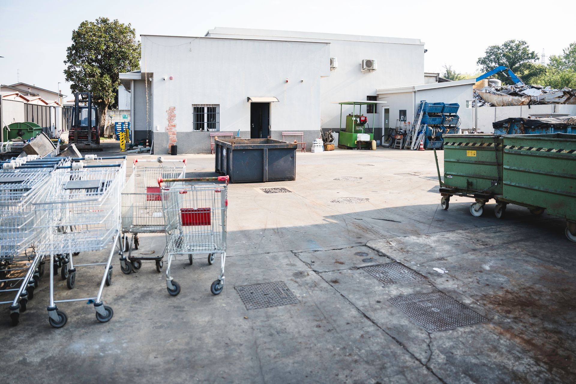 Cassonetti industriali blu e arancioni allineati su un molo in riva al mare