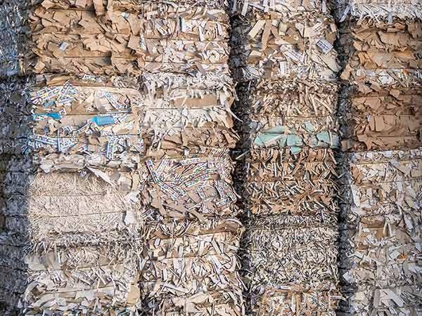 Pacchi di carta impilati con strati di carta sminuzzata multicolore legati da cinghie verticali