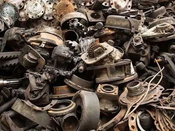 Cumulo di rottami metallici arrugginiti e parti di macchinari assortiti, accatastati insieme