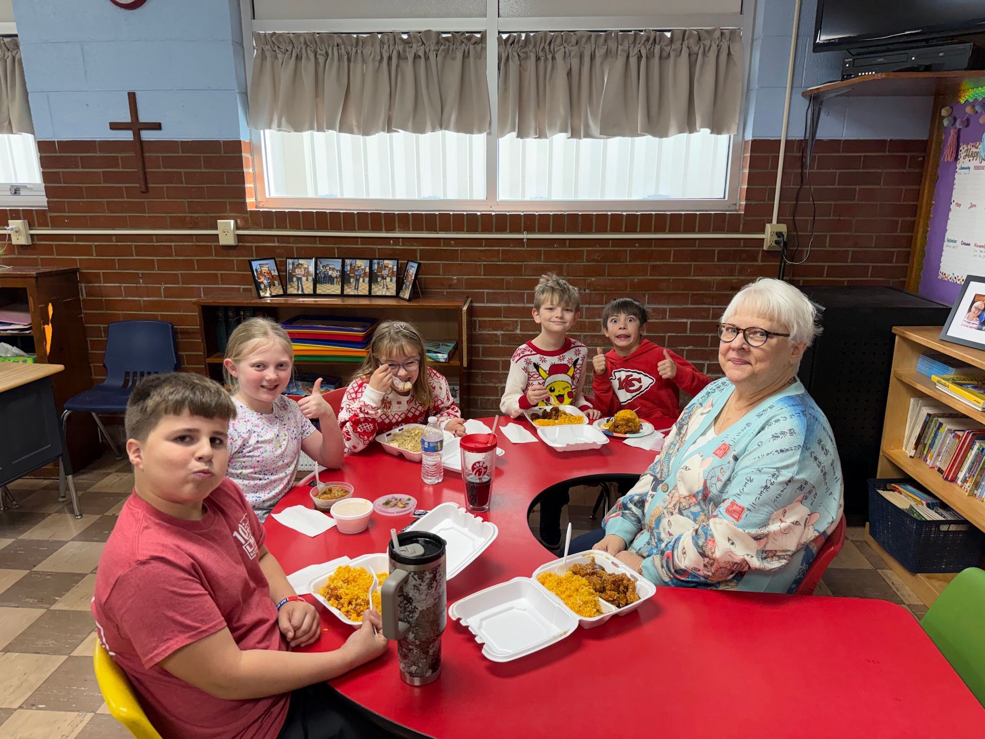 A woman and a child are sitting at a table with plates of food at a PTL meeting.