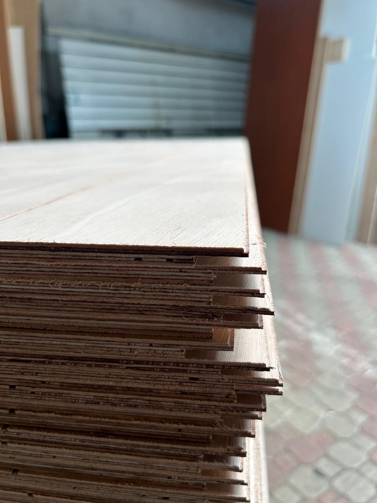 Pila di assi di legno chiaro con bordi grezzi su un tavolo all'interno