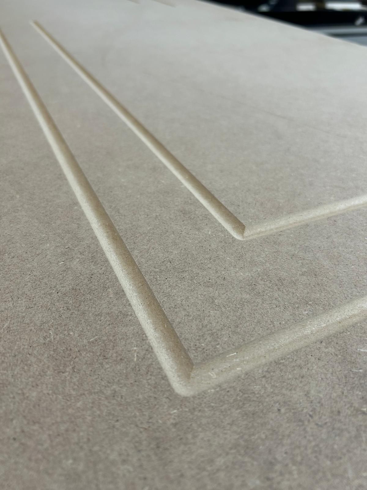 Primo piano di una superficie piastrellata beige con scanalature diagonali in rilievo che formano un motivo angolare.
