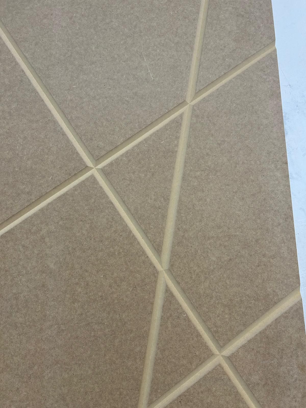 Primo piano di un soffitto beige con una texture caratterizzata da linee di griglia bianche intersecanti e un bordo della parete blu.