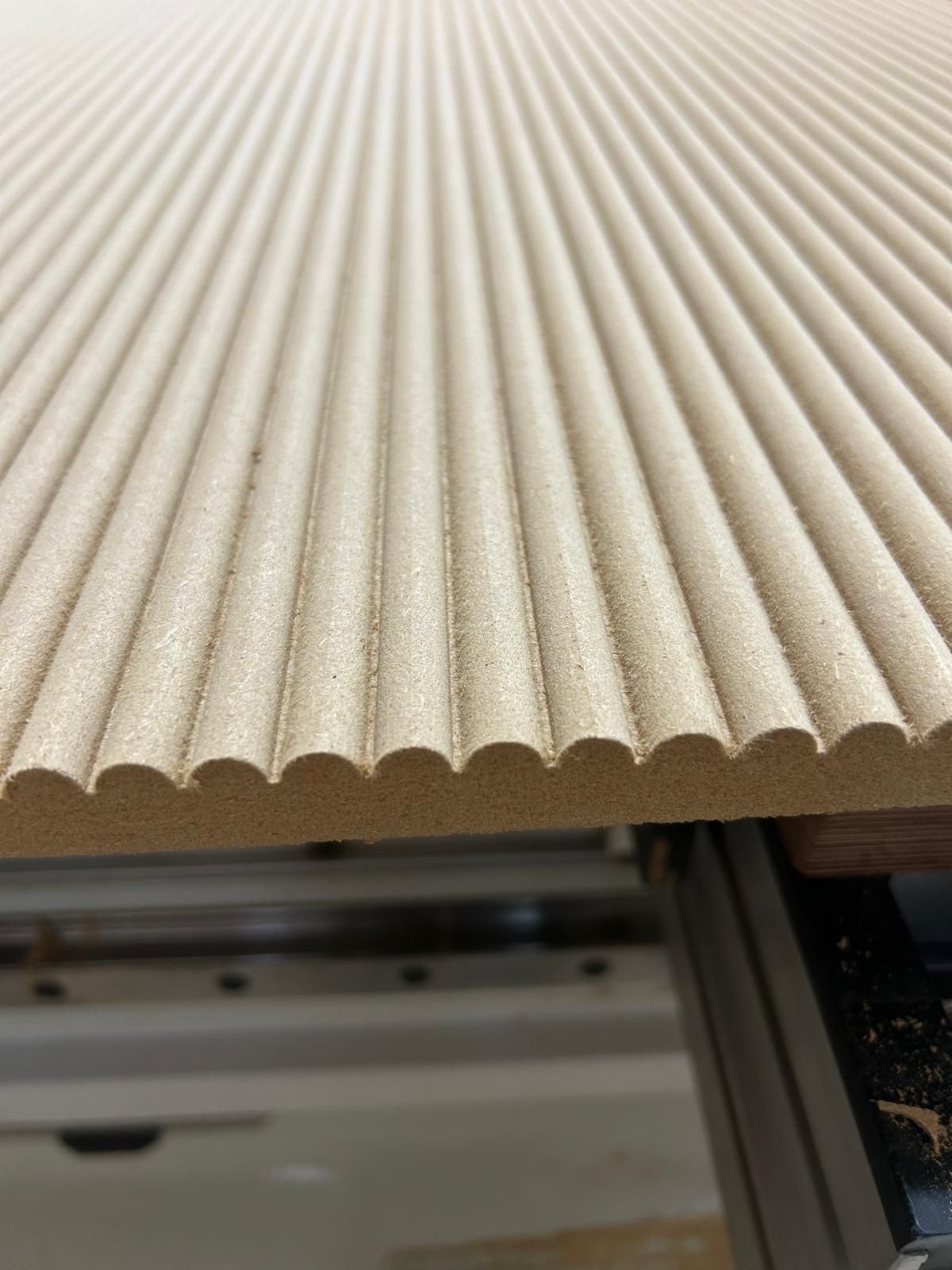 Primo piano di un foglio di cartone ondulato beige appoggiato sulla superficie di una macchina.